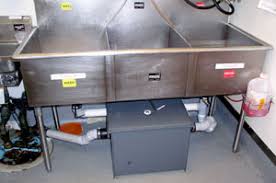Passive grease trap installed under commercial 3-compartment sink in restaurant kitchen - under-sink grease interceptor for food service establishments
